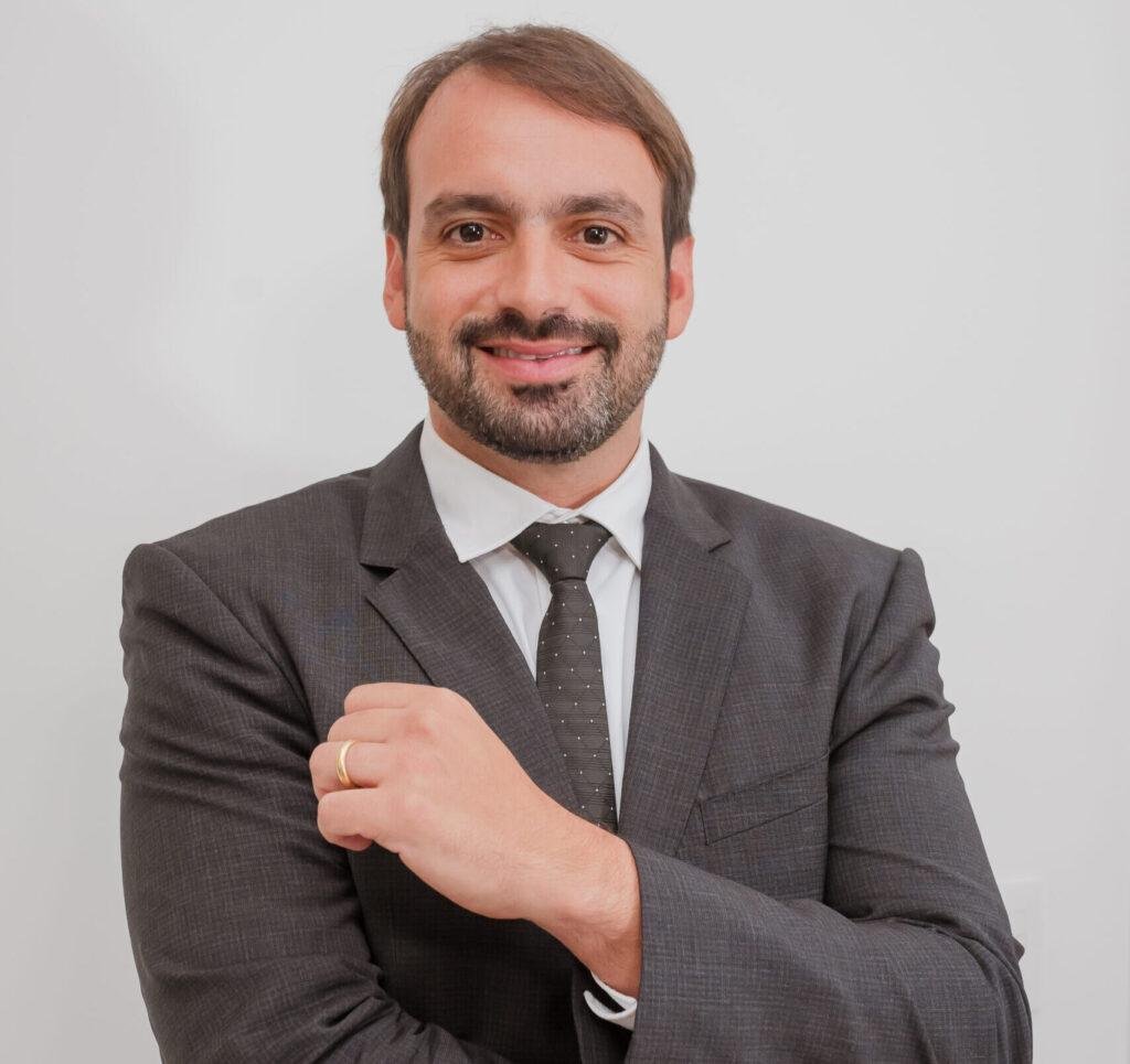 Empresário confiante em traje de negócios com braços cruzados, transmitindo sucesso na aceleração comercial e crescimento de negócios.